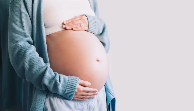 Une femme enceinte qui tient son ventre arrondi