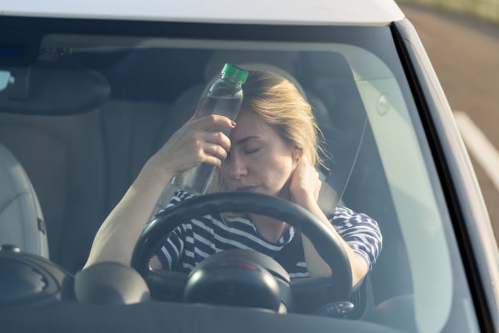 Une femme a chaud dans une voiture