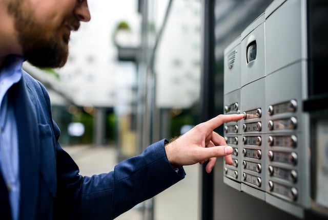 Un homme sonnant &agrave; l'interphone