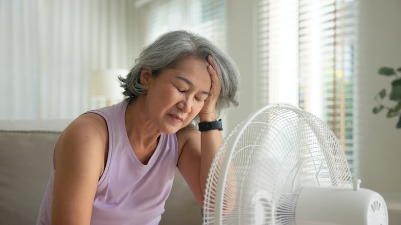 Une femme devant un ventilateur