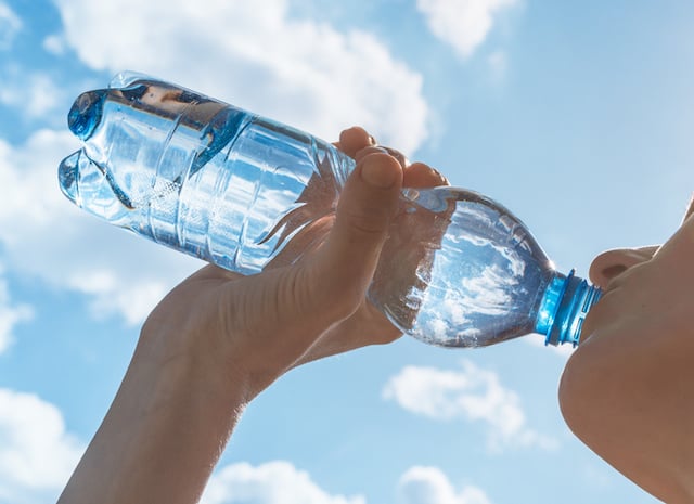 Une femme qui boit une bouteille d'eau
