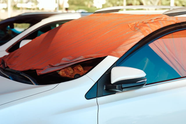 Couverture de survie install&eacute;e sur le pare-brise d'une voiture