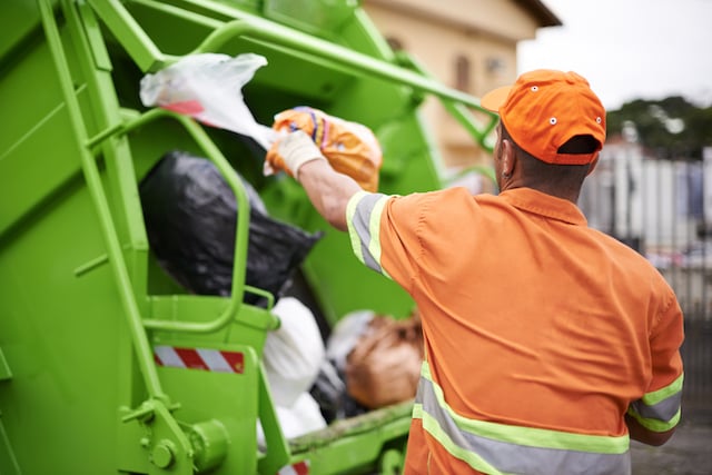 Des &eacute;boueurs en train de charger des ordures