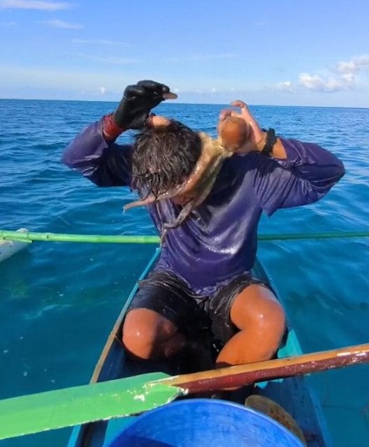 Le p&ecirc;cheur tentant de se d&eacute;barrasser du poulpe  