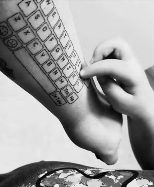 Hunter en train de taper sur le clavier tatou&eacute; sur le bras de sa m&egrave;re 