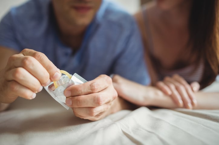 Un couple utilise un pr&eacute;servatif