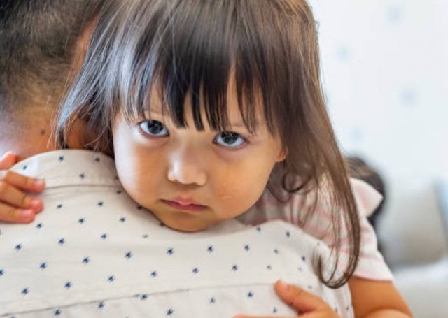 Une fillette d'origine asiatique dans les bras de son p&egrave;re