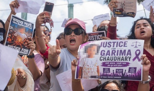 Des manifestants brandissent une banderole montrant le visage de l'enfant qui a &eacute;t&eacute; tu&eacute;