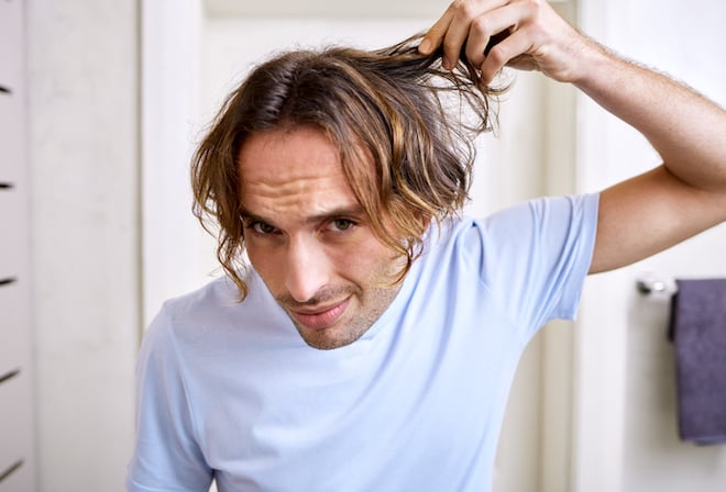Un homme v&eacute;rifie ses cheveux