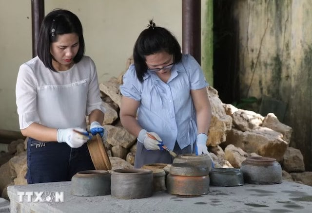 Des expertes du Mus&eacute;e de Ninh Binh en train d'examiner les jarres