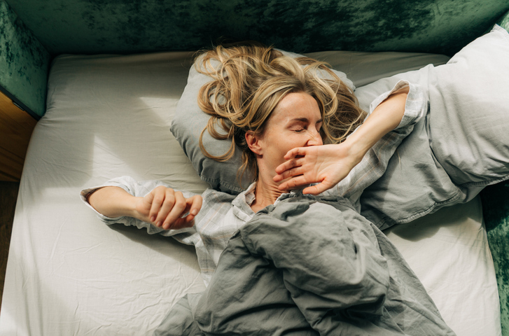 Une femme baille dans son lit