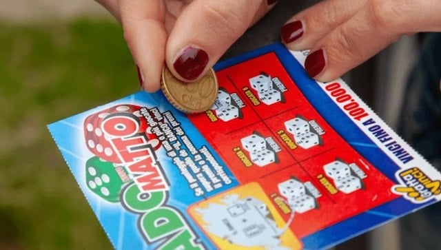 Une femme en train de gratter un ticket