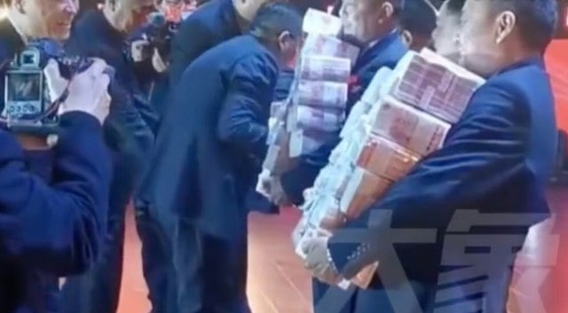 Capture d'&eacute;cran montrant les employ&eacute;s ramasser les billets