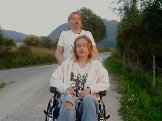 Maria Kovalchuk en fauteuil roulant poussé par sa mère