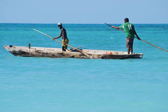 Pêcheurs à bord d’un bateau traditionnel naviguant sur une mer turquoise © Zeynep Gokalp