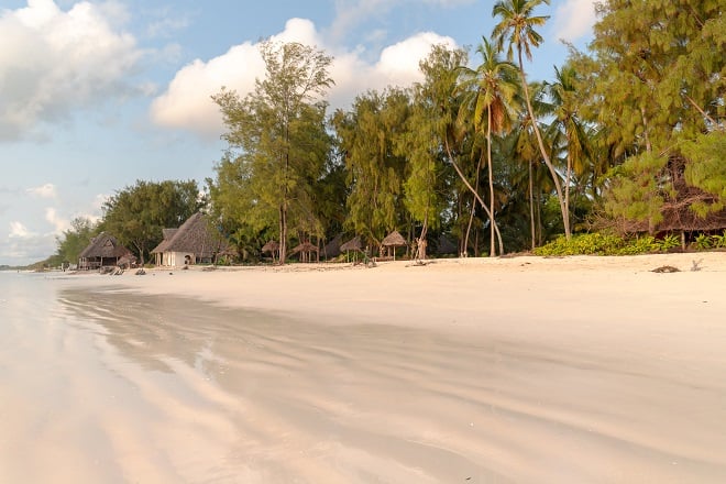 Plage de sable avec des maisons traditionnelles © MARIOLA GROBELSKA