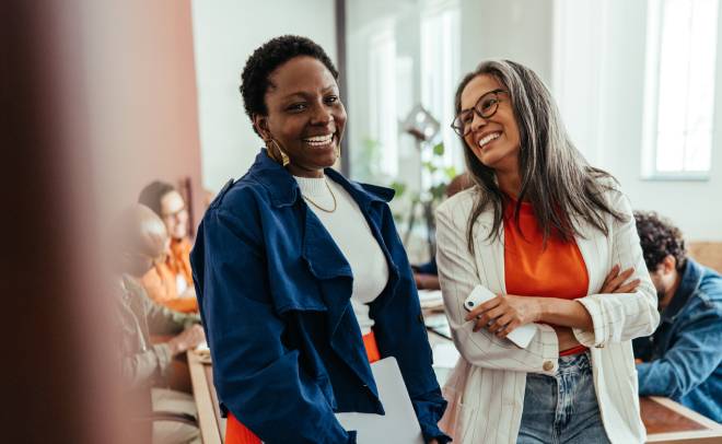 Deux coll&egrave;gues souriantes discutant