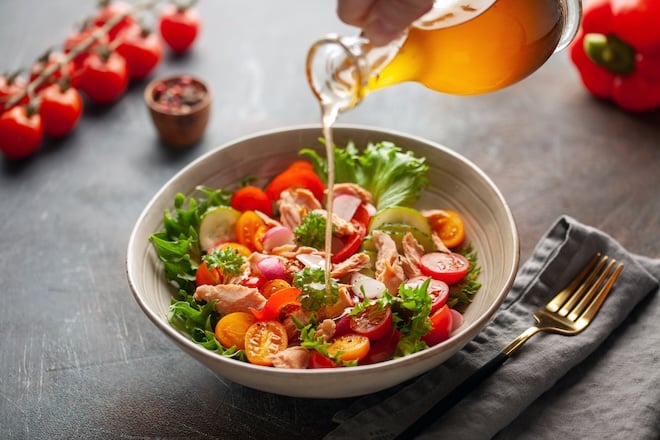 arroser une salade d'été avec une vinaigrette
