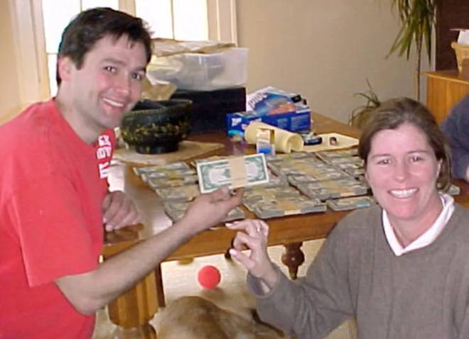 Bob Kitts et Amanda Reece posant devant des billets de banque