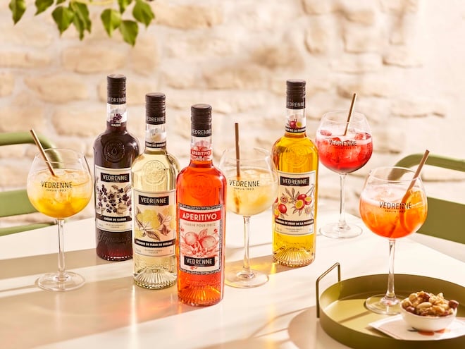 gamme de liqueurs Vedrenne avec des cocktails sur une table d'apéro