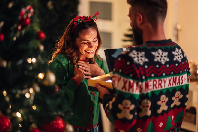 Homme offrant un cadeau de Noël à une femme heureuse