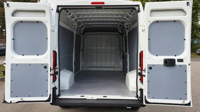 Int&eacute;rieur d'un fourgon blanc avec portes arri&egrave;res ouvertes