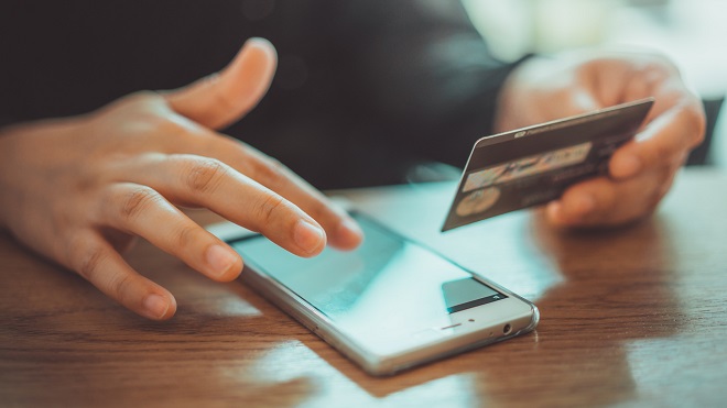 Homme payantavec sa carte bancaire sur son téléphone