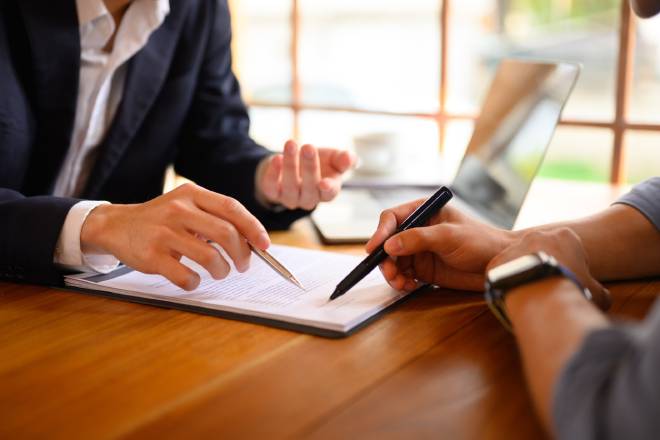 Agent pointant un contrat papier &agrave; un client