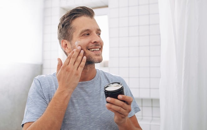 Homme appliquant de la crème sur son visage
