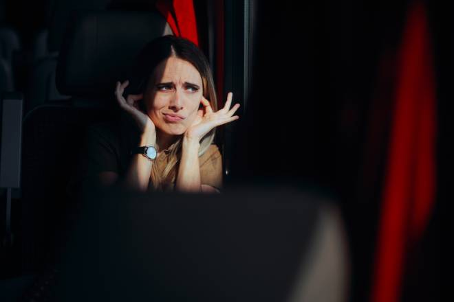 Voyageuse se bouchant les oreilles