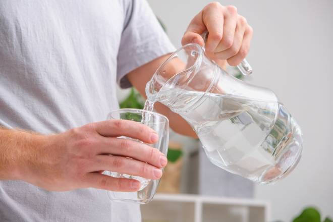 Homme se servant un verre d'eau