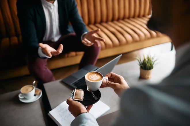 deux personnes qui boivent un café lors d'un entretien professionnel