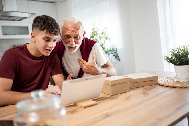 Un grand-père et son petit-fils passant un appel vidéo sur une tablette