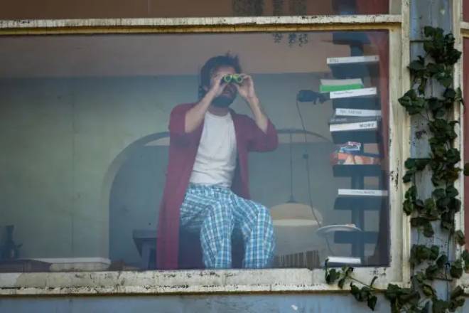 Homme regardant avec des jumelles dans un panneau publicitaire de Netflix