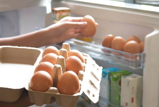 Personne rangeant les oeufs dans le r&eacute;frig&eacute;rateur