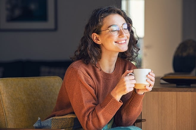 Jeune femme heureuse buvant du thé