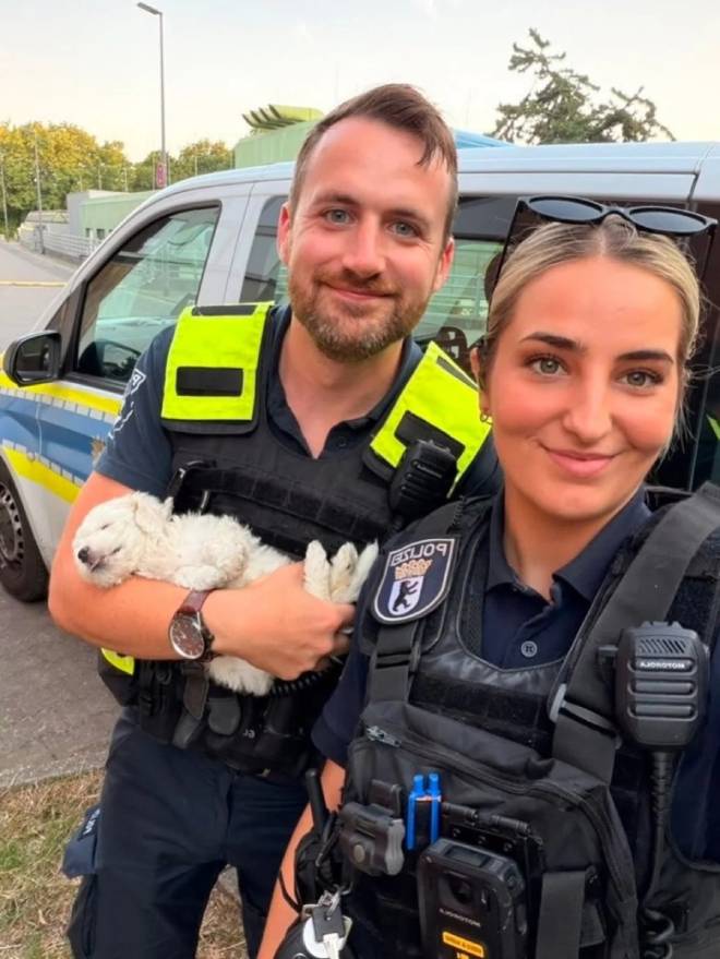 Deux policiers de Berlin tenant un chiot dans leurs bras