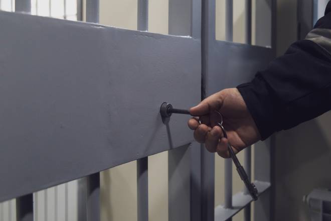 Gardien fermant une porte de prison