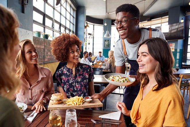 Serveur apportant les plates à une table
