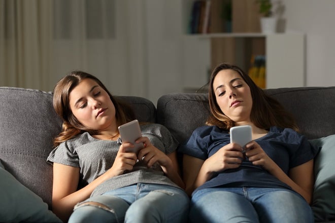 Jeunes filles ennuyées scrollant sur leur téléphone