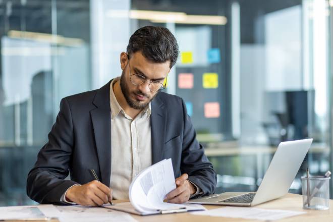 Travailleur signant des documents dans un bureau