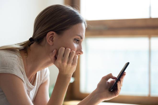 Jeune femme triste devant son smartphone