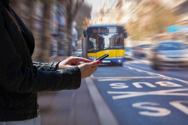Pi&eacute;tonne avec son t&eacute;l&eacute;phone dans les mains alors qu'un bus approche