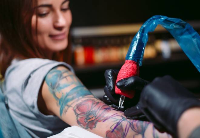 Jeune femme se faisant tatouer le bras