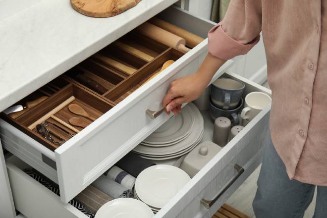 Femme ouvrant les tiroirs d'une cuisine