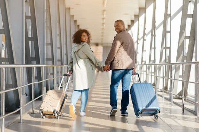 Couple heureux voyageant avec valises
