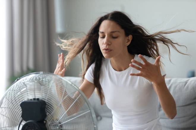 Jeune felle devant un ventilateur en marche