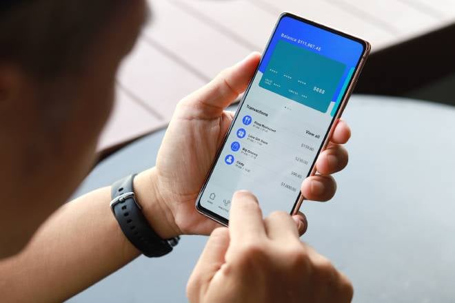 Homme g&eacute;rant ses finances sur une application