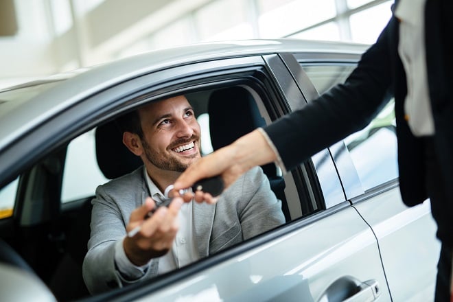 Concessionnaire donnant les clés de voiture à un acheteur