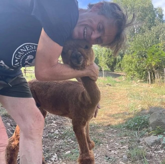 Willem Dafoe dans sa ferme avec un alpaga